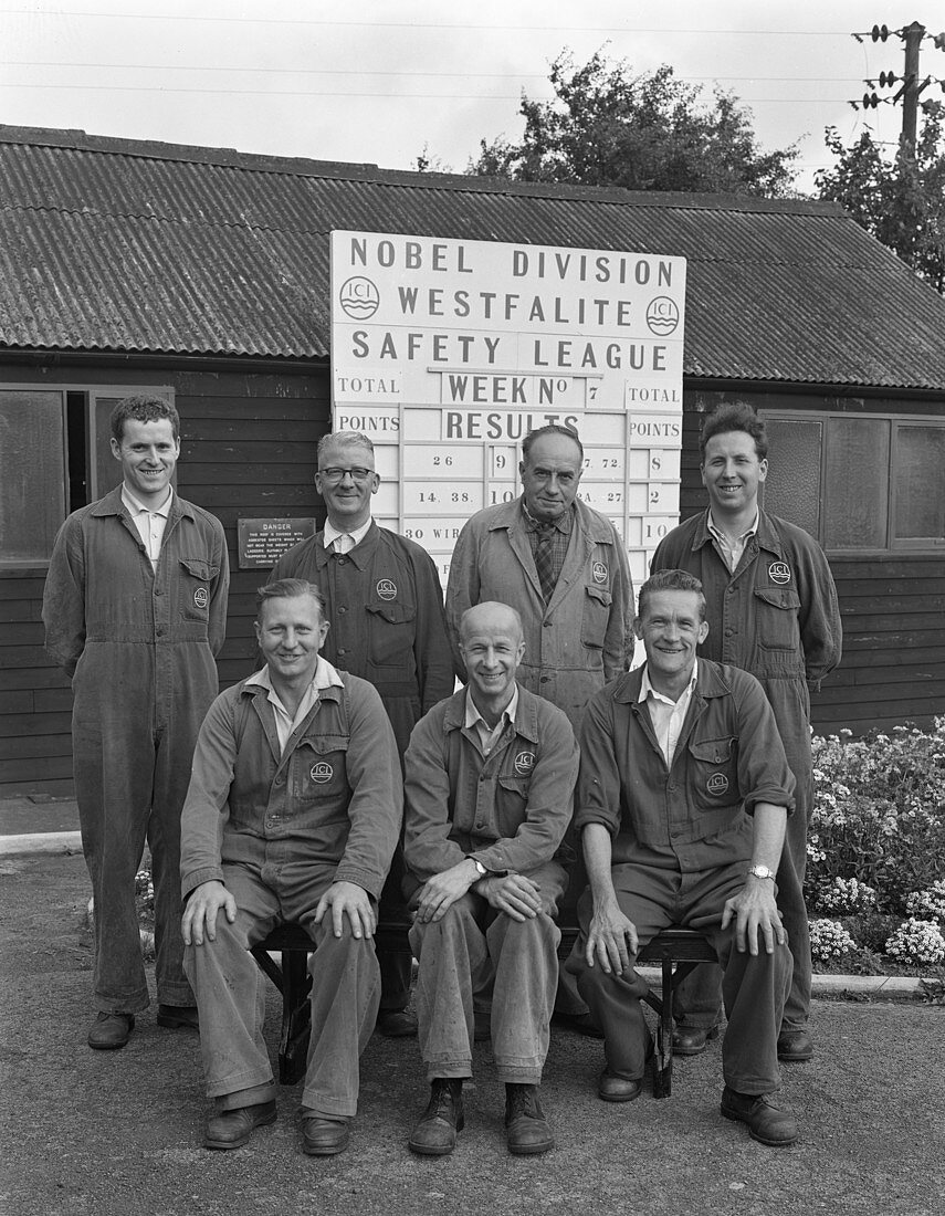 ICI powder works team in front of Safety League board, 1962
