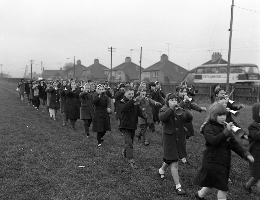 Children marching with home made bugles, 1964