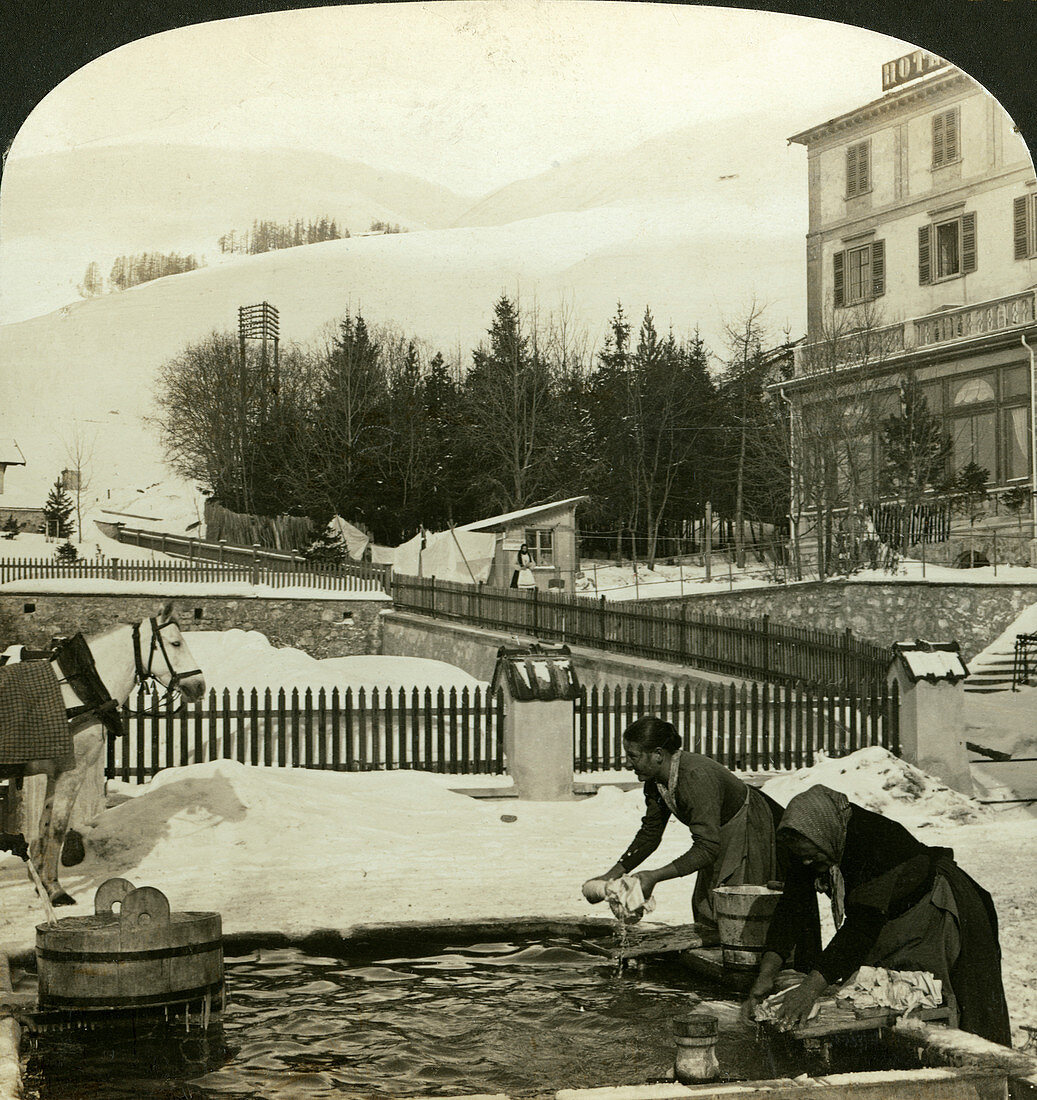 Women washing clothes at public fountain in midwinter