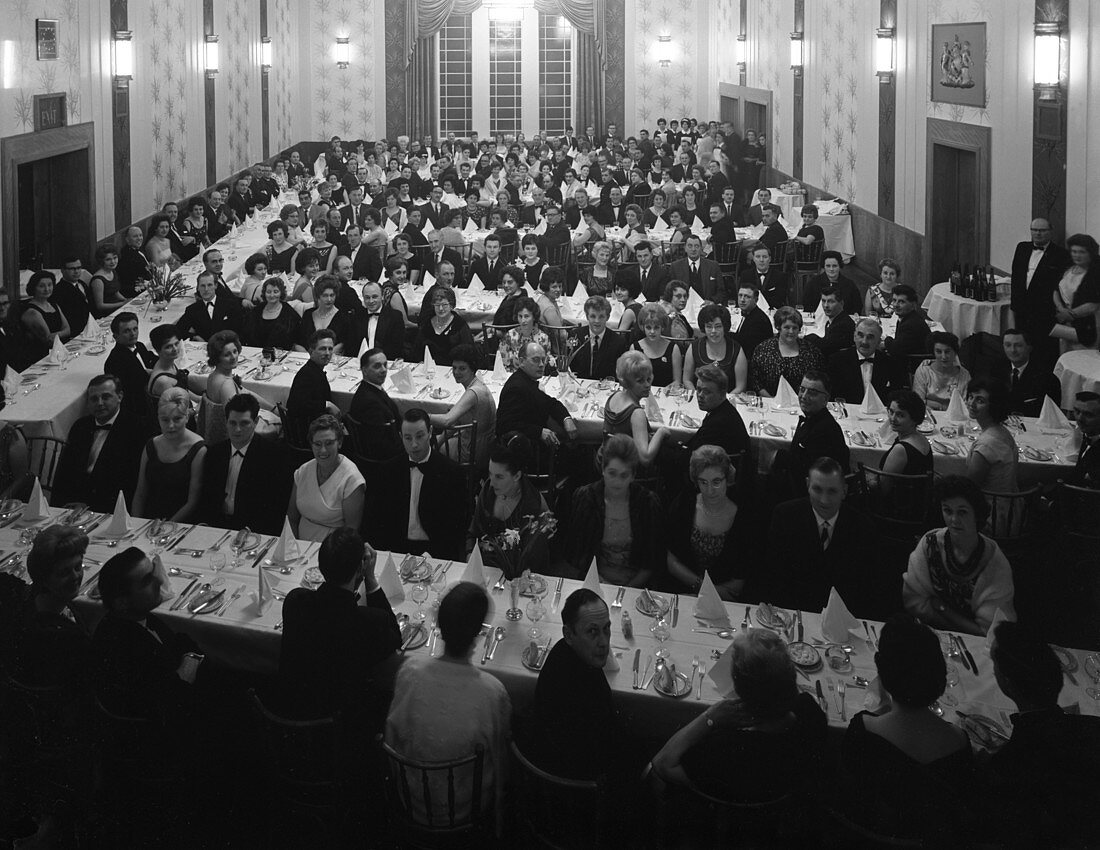 Guests seated before dinner at a social evening, 1963