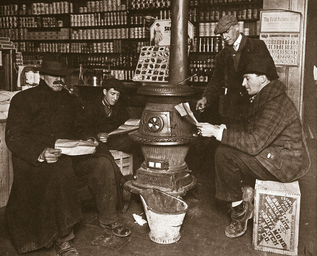 A group of men around a stove in a shop, USA, c1910