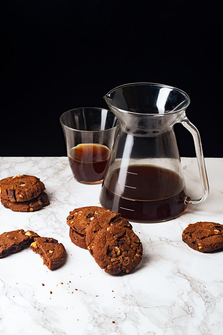 A pile of chocolate cookies with pour over coffee