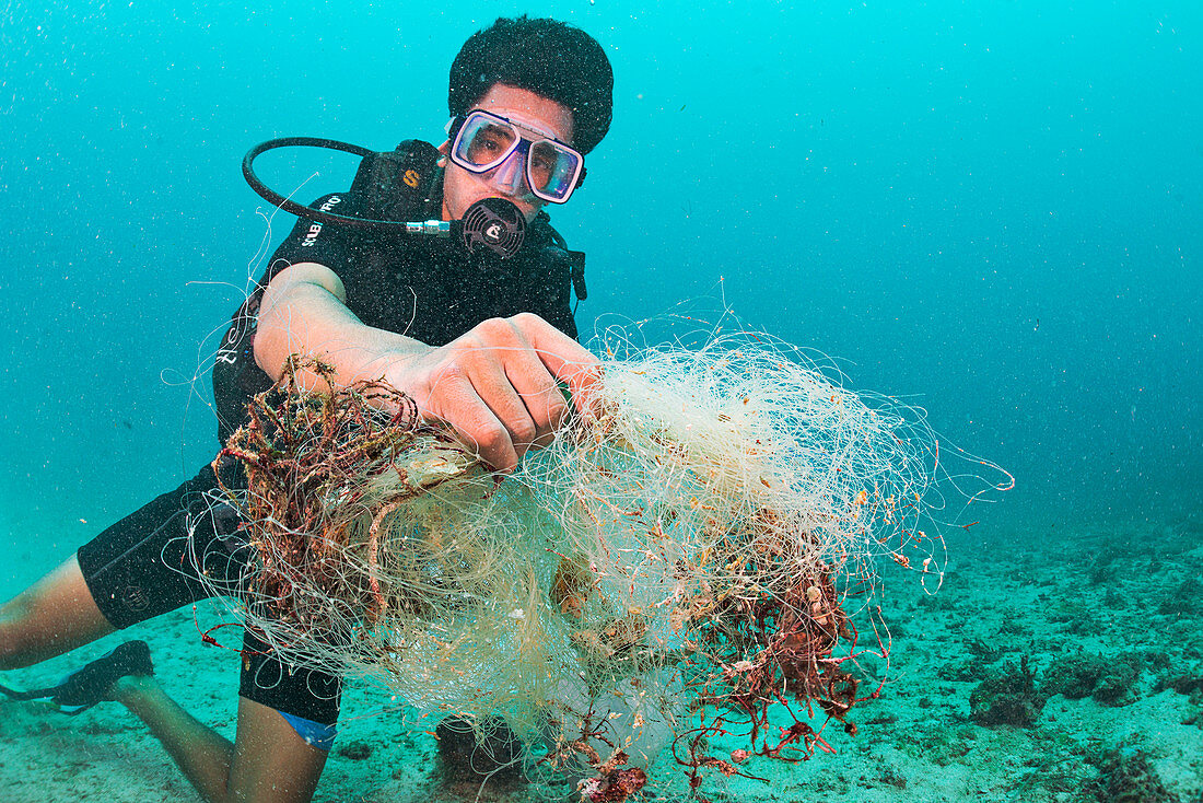 Scuba diver collecting waste fishing net