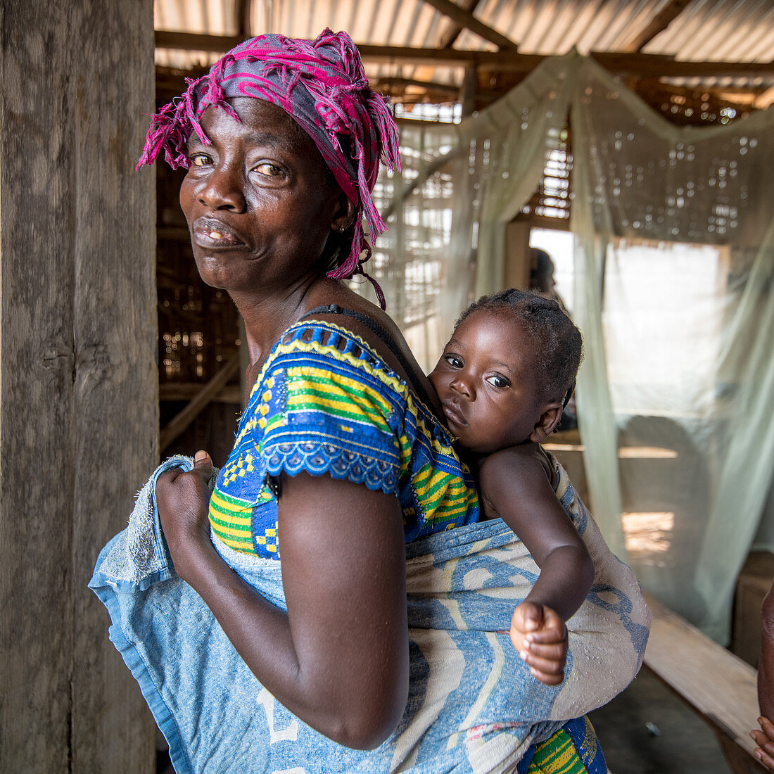 Woman with young child wrapped to her back, Liberia