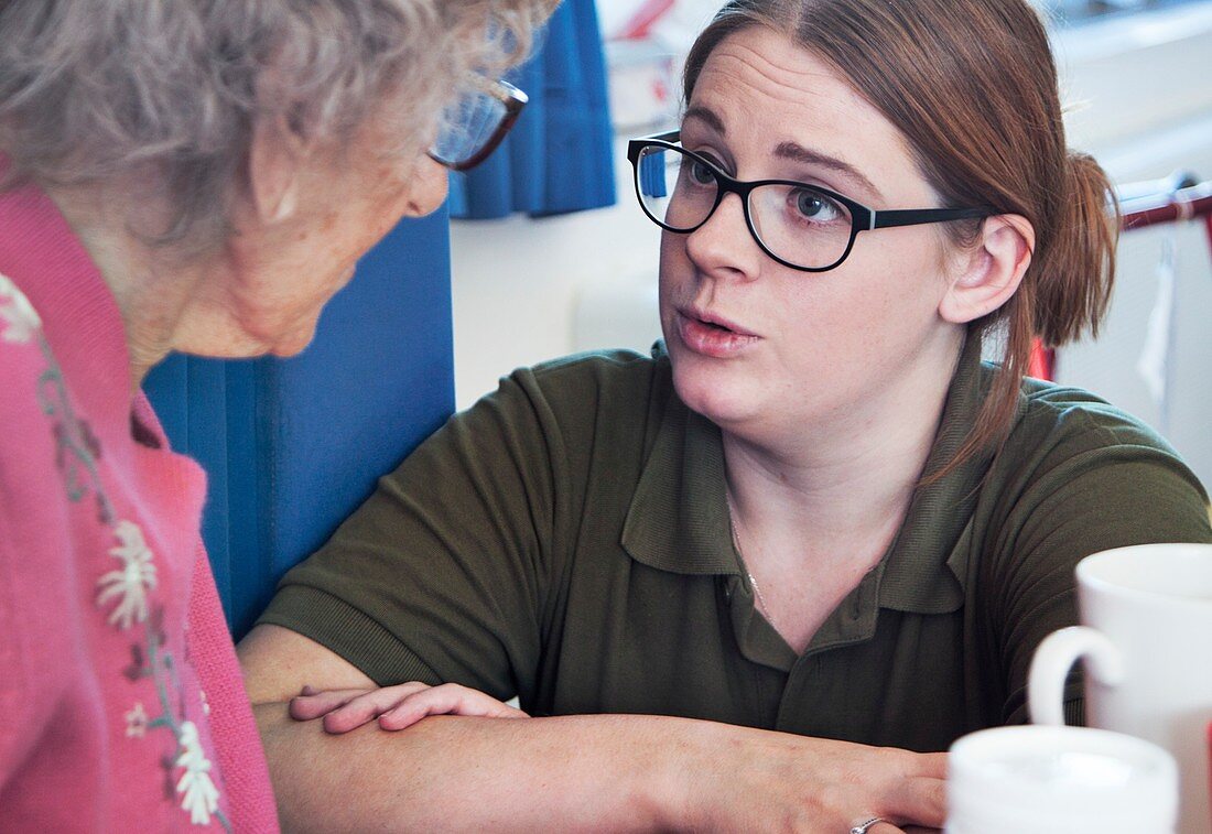 Hospital discharge officer talking to an elderly patient