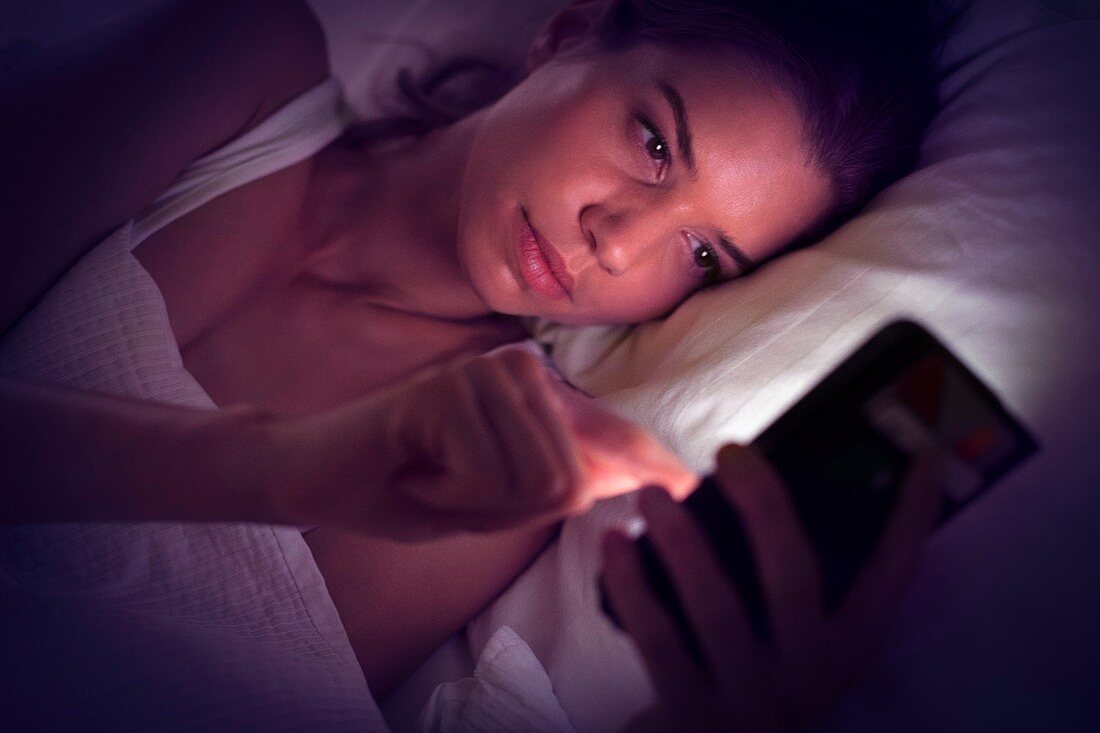 Young woman using digital tablet in bed