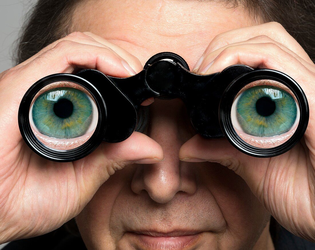 Man holding binoculars with eyes on lenses