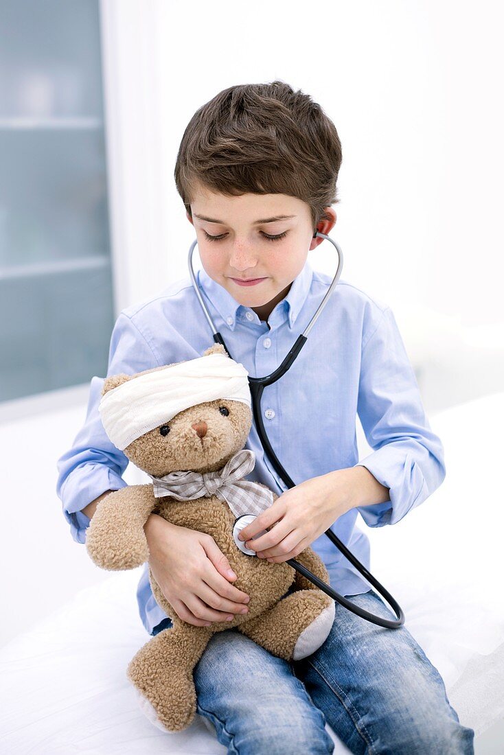 Boy role playing with teddy bear and stethoscope