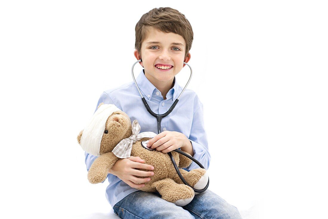 Boy playing with teddy bear and stethoscope