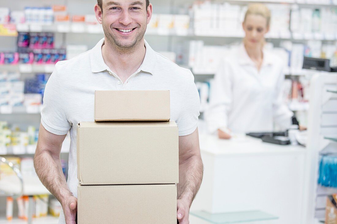 Courier carrying boxes in pharmacy