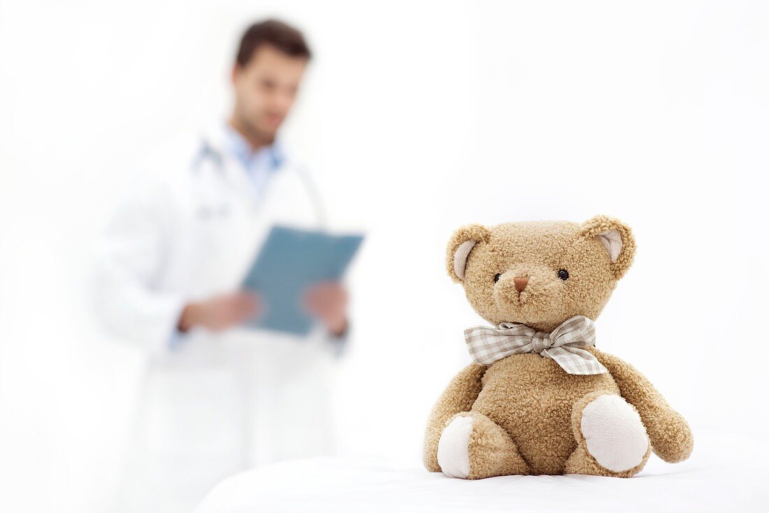 Teddy bear with doctor in background
