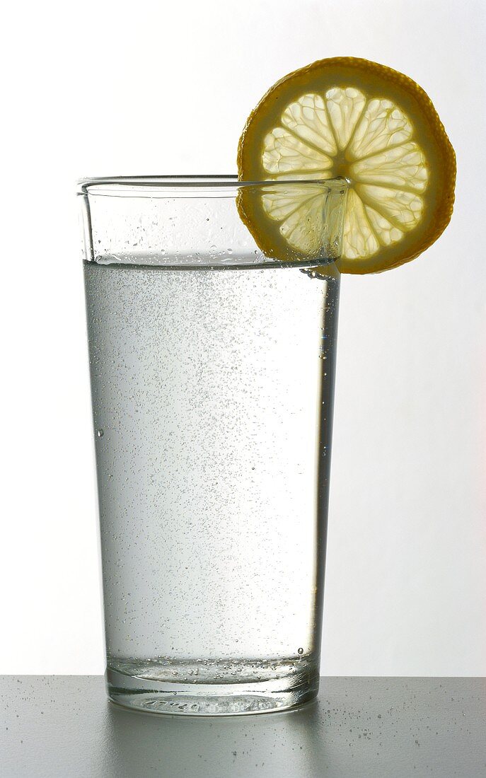 Glass of fizzy mineral water with lemon slice