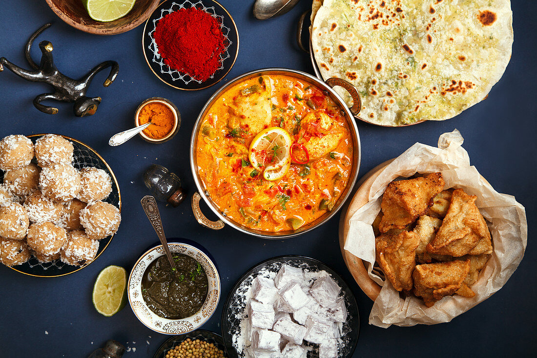 Indian chicken tikka masala, samosas, patties and sweets with mint chutney and spices