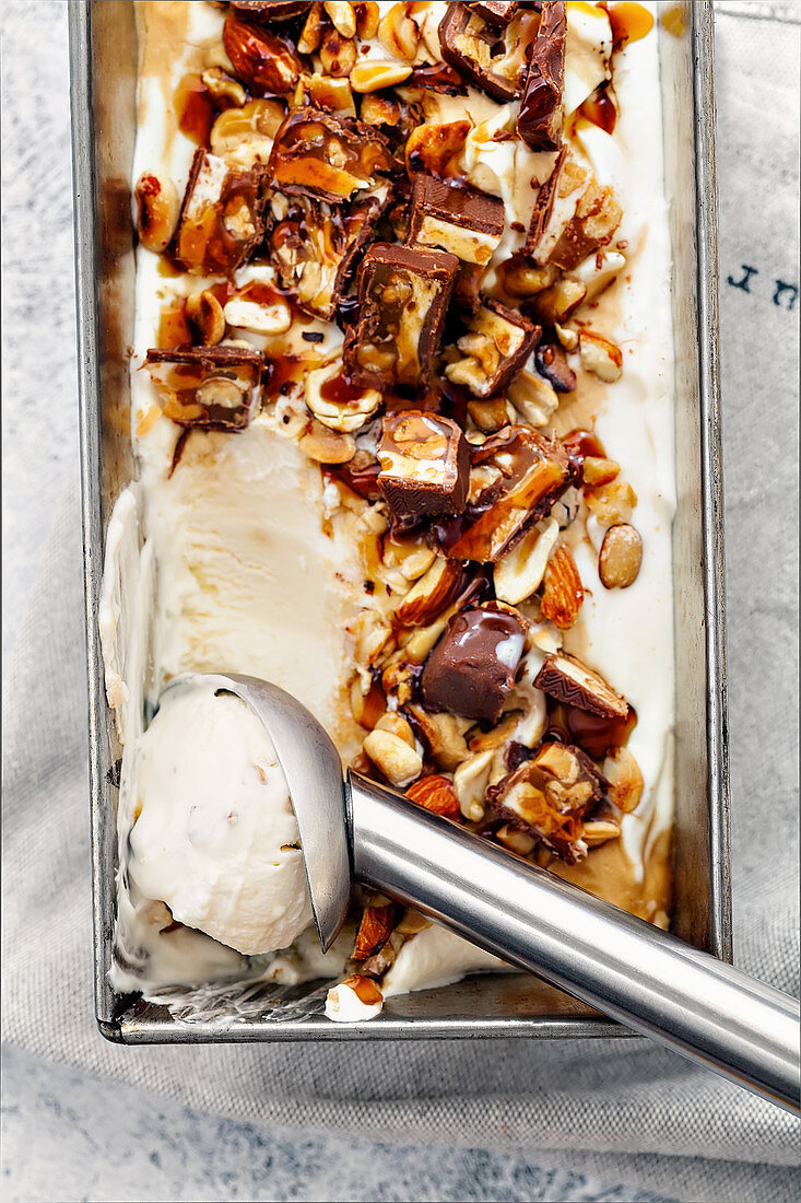 Eiscreme mit Schoko-Karamell-Riegel, gebratenen Erdnüssen und Haselnüssen