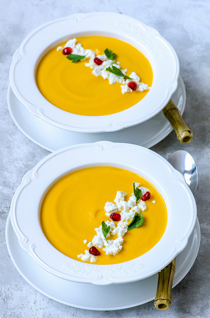 Pumpkin cream soup with feta, parsley and pomegranate seeds