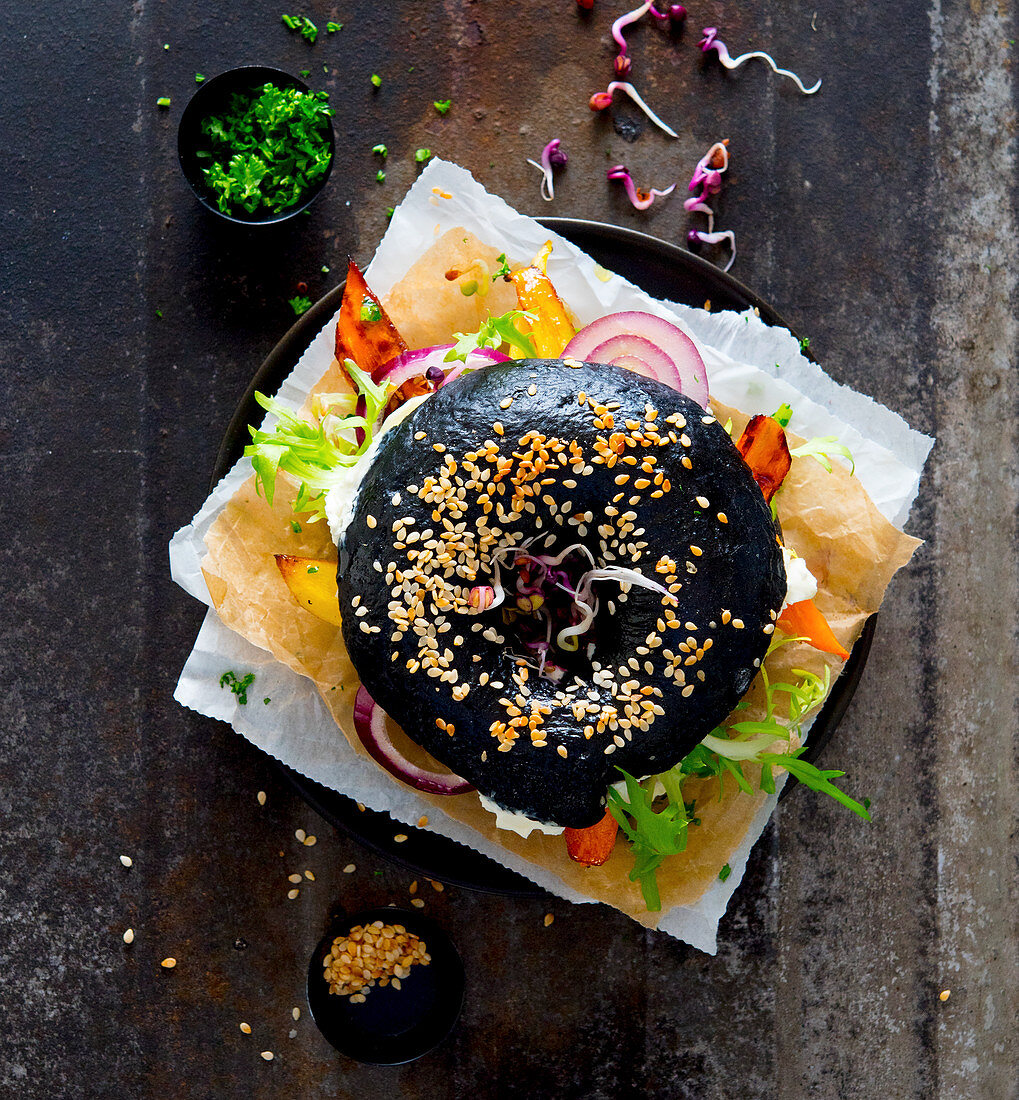 A black sesame bagel with vegetables