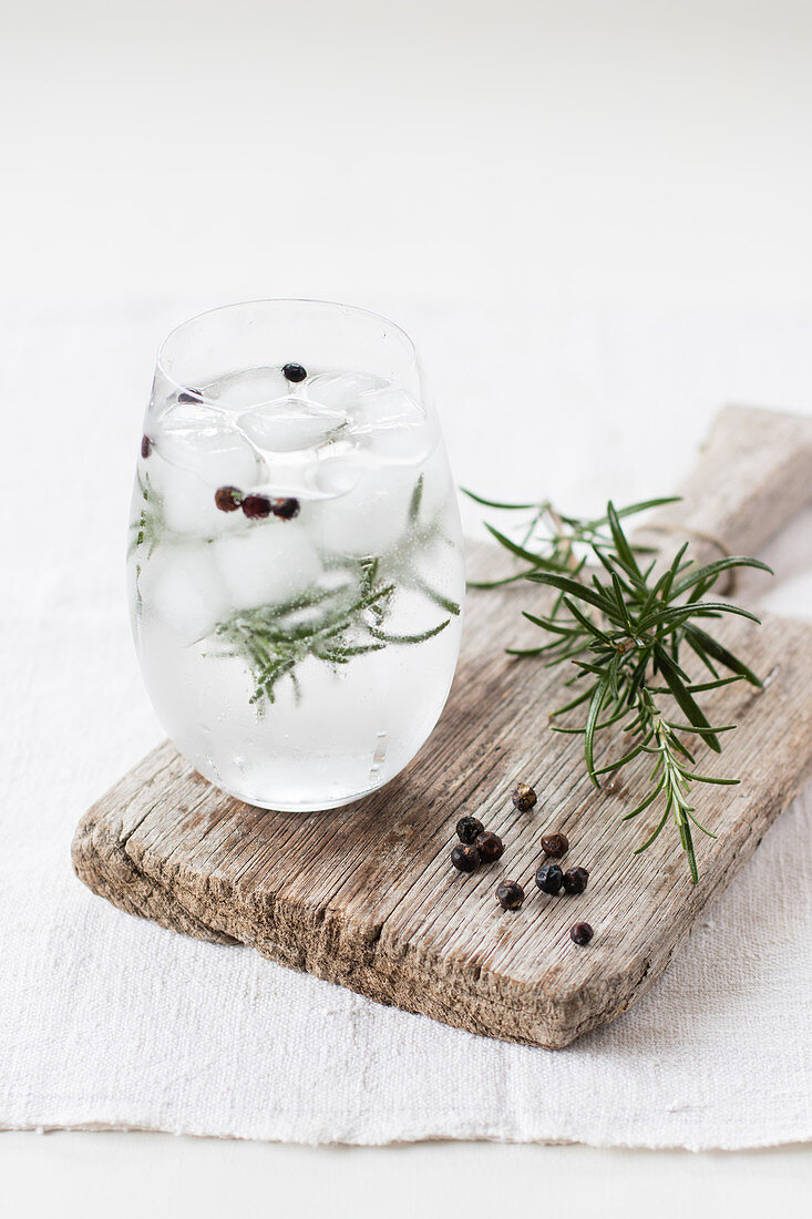 Gin Tonic mit Rosmarinzweig und Wacholderbeeren