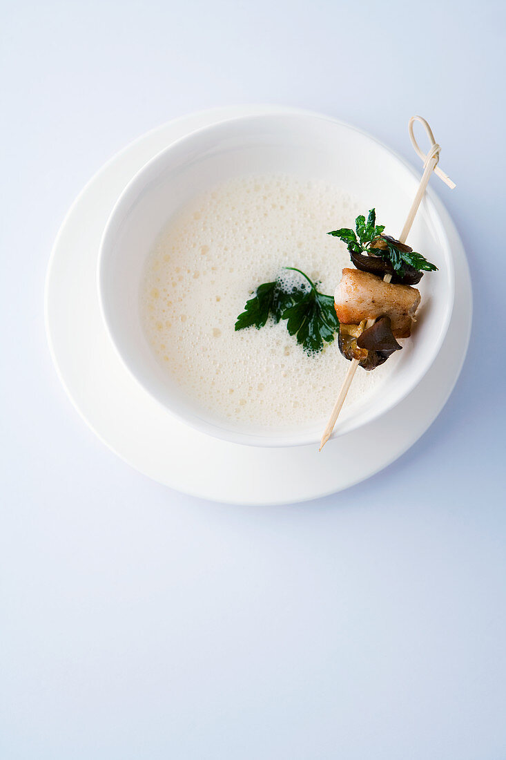 White tomato soup with a rabbit and snail skewer