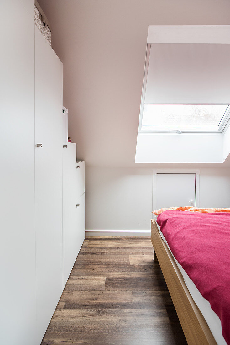 Cupboards below sloping ceiling in attic bedroom