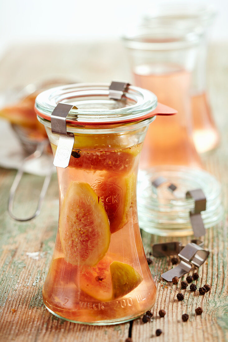 Homemade fig vinegar in jars on a wooden surface