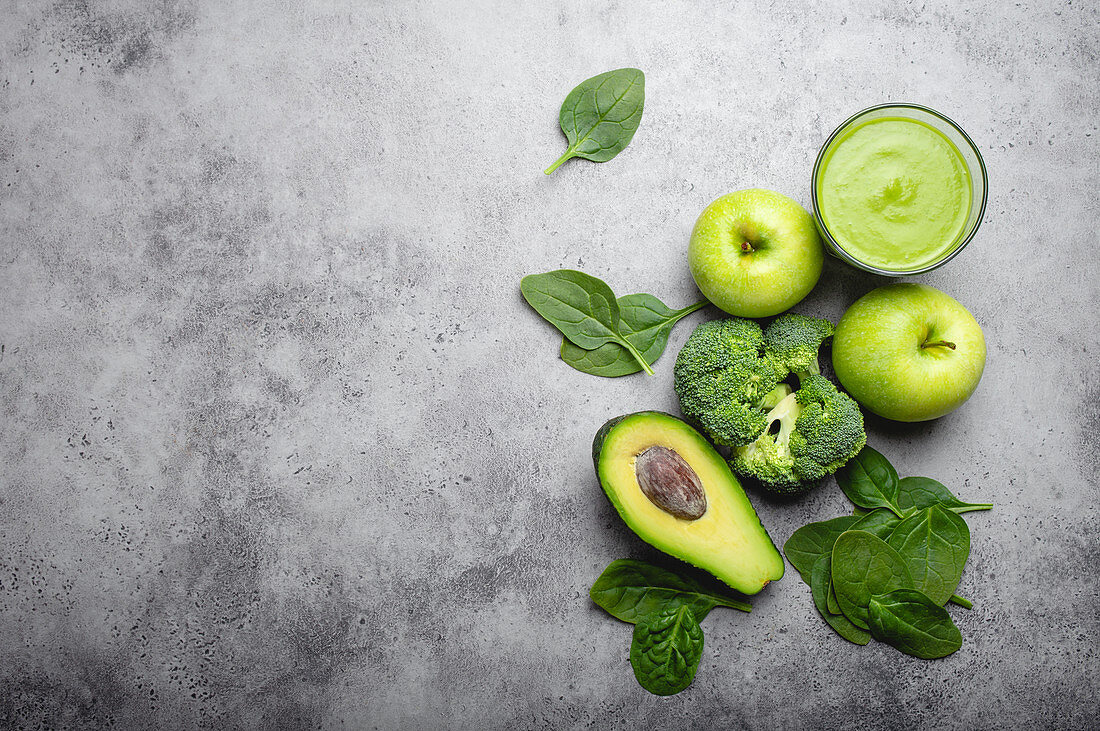Ingredients for making green healthy smoothie with broccoli, apples, avocado and spinach