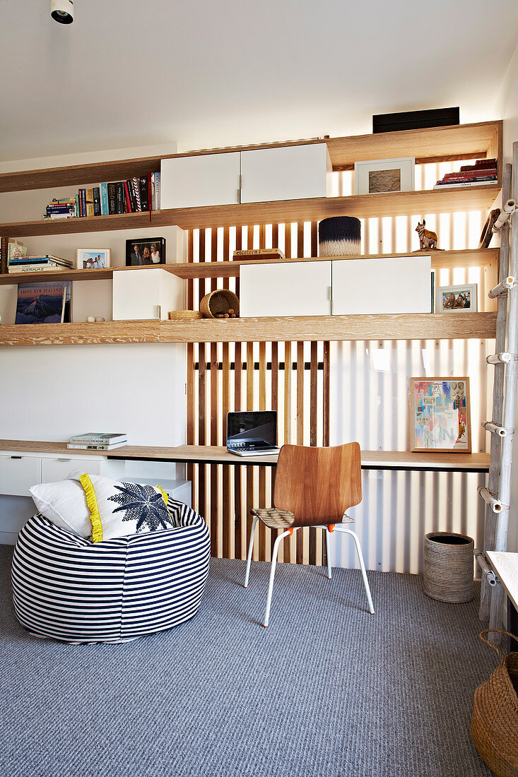 Open shelf above desk and striped beanbag in home office