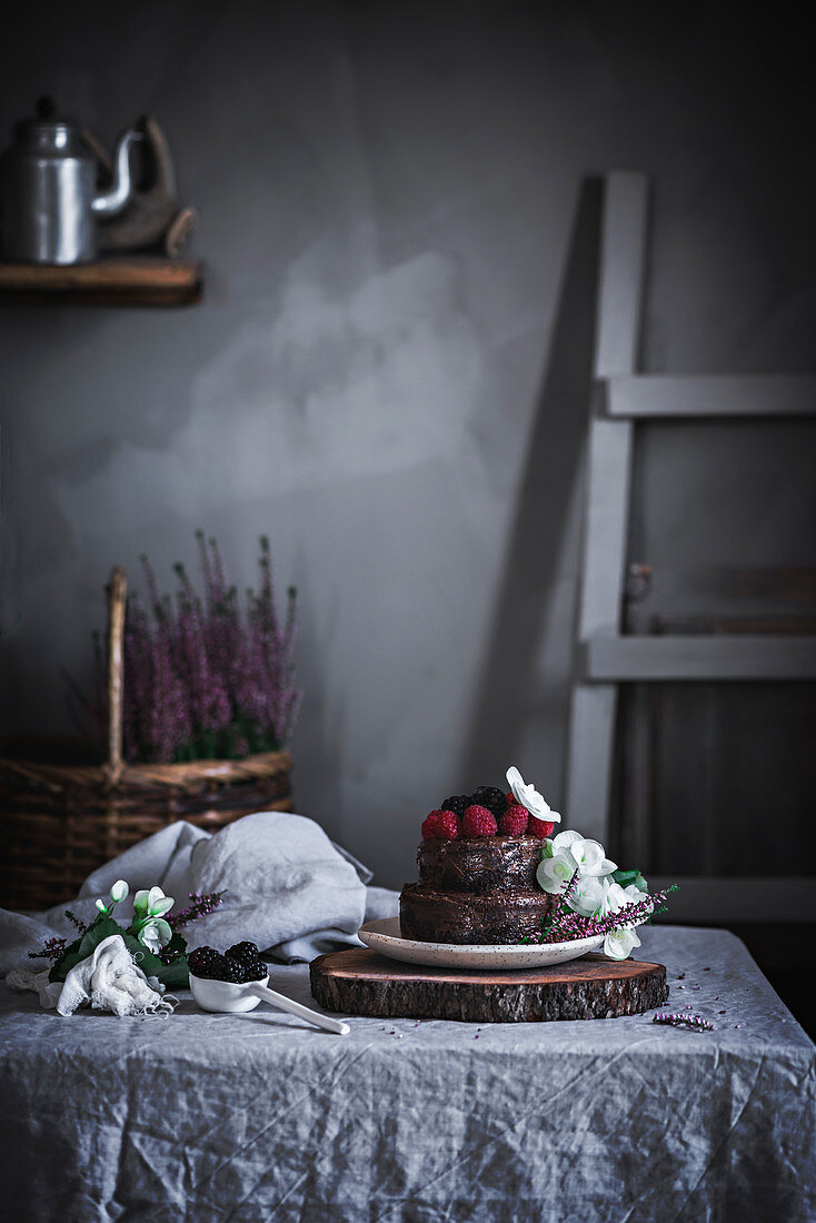 Zweistöckiger Mini-Schokoladenkuchen auf Tisch in ländlicher Küche