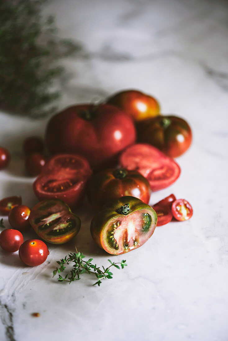 Verschiedene Tomaten und Tomatenhälften auf Marmortisch