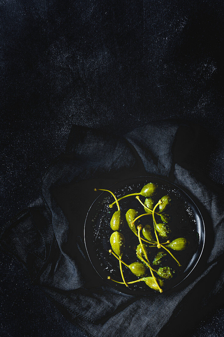 Capers in vinegar with olive oil and salt