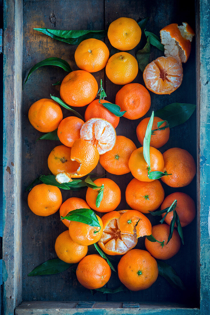 Mandarinen in Holzsteige, teils geschält