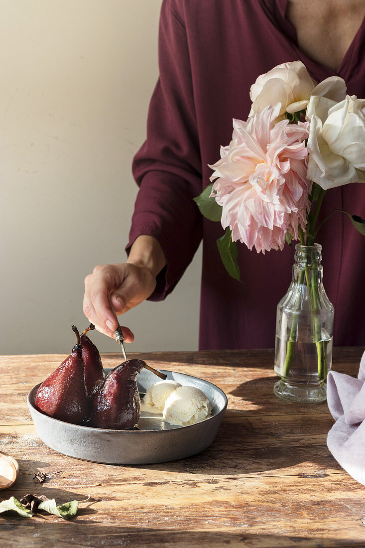 Woman with spoon in bowl with ice cream and pears