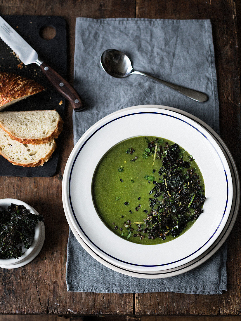 Spinach soup garnished with sauteed lentils, kale crisps, pasley and lemon zest