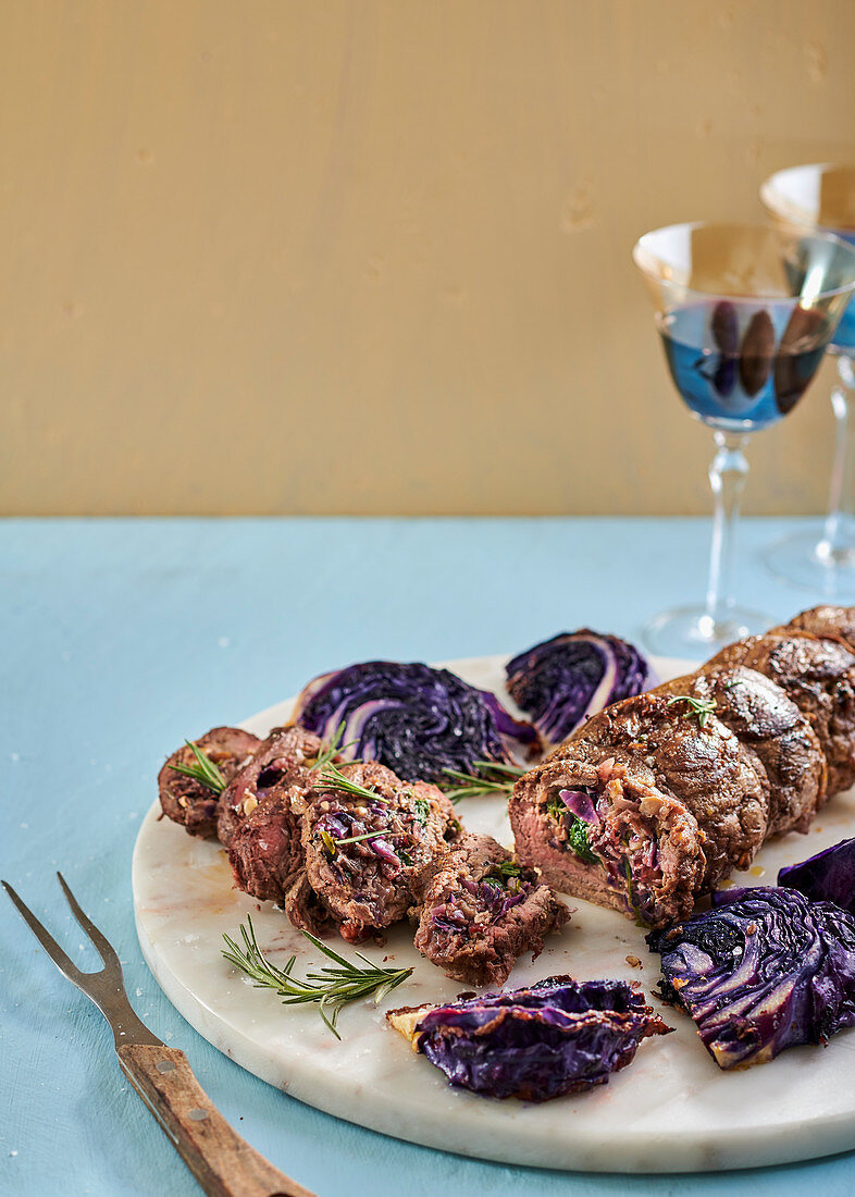 Nut, cranberry, rosemary and red cabbage stuffed beef fillet with roasted cabbage wedges