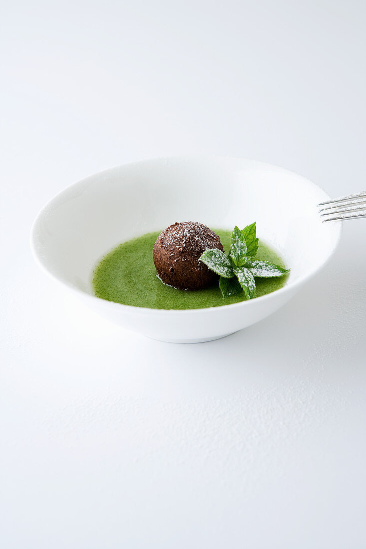 Cold mint soup with a baked chocolate ball