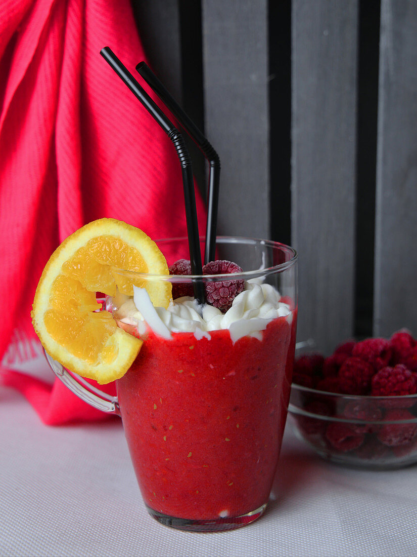 A pink smoothie with raspberries