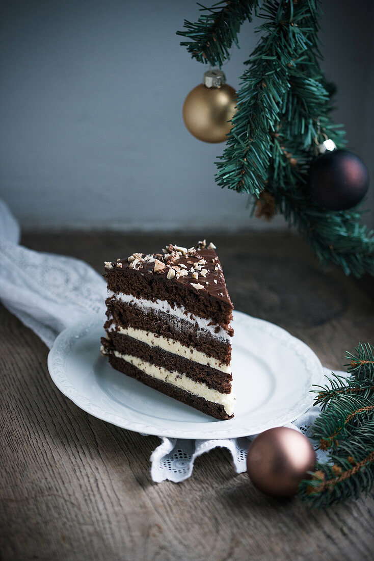Ein Stück vegane Haselnuss-Schokoladen-Buttercreme-Torte mit Weihnachtsdeko