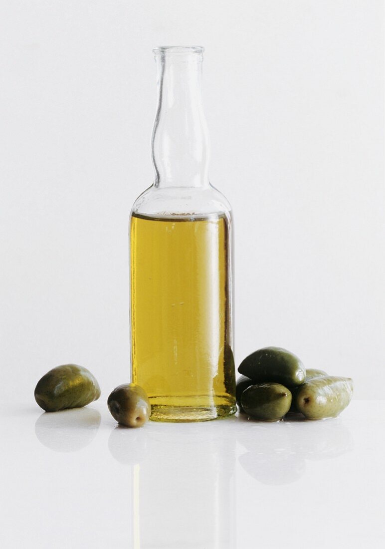 A Bottle of Olive Oil with Green Olives