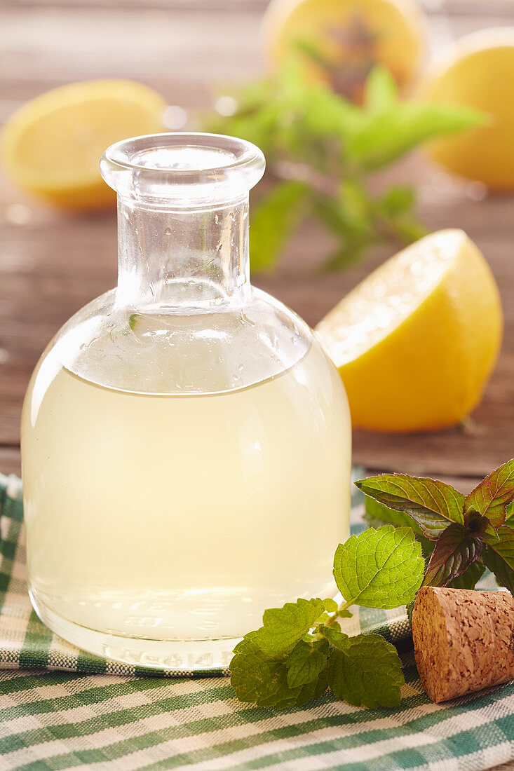 Homemade lemon syrup with mint and lemon balm in a vial