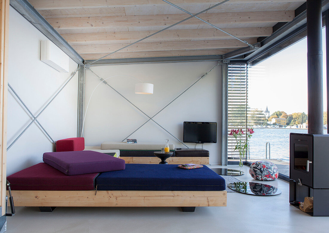 Modernes Hausboot: Maßgefertigte Sofas, Holzofen und Fernseher im Wohnraum