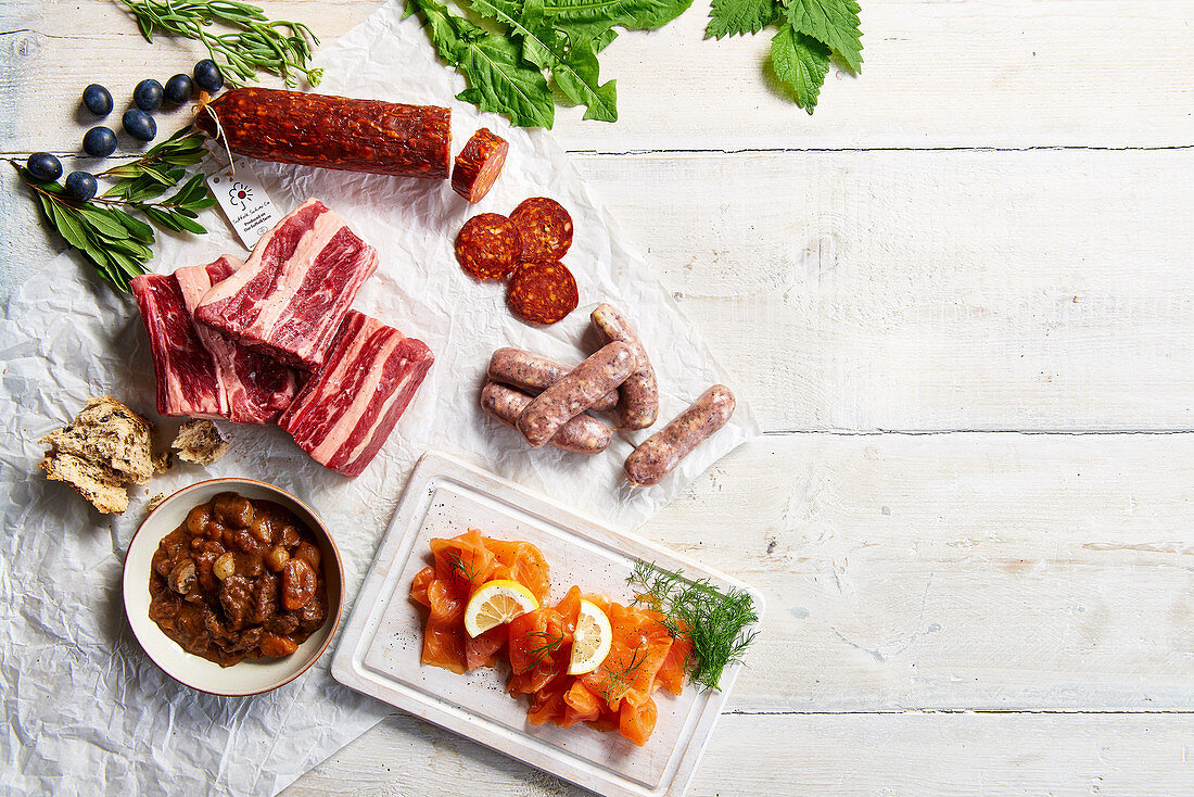 Mixture of raw meat, cured sausage, smoked salmon, and beef stew with bread