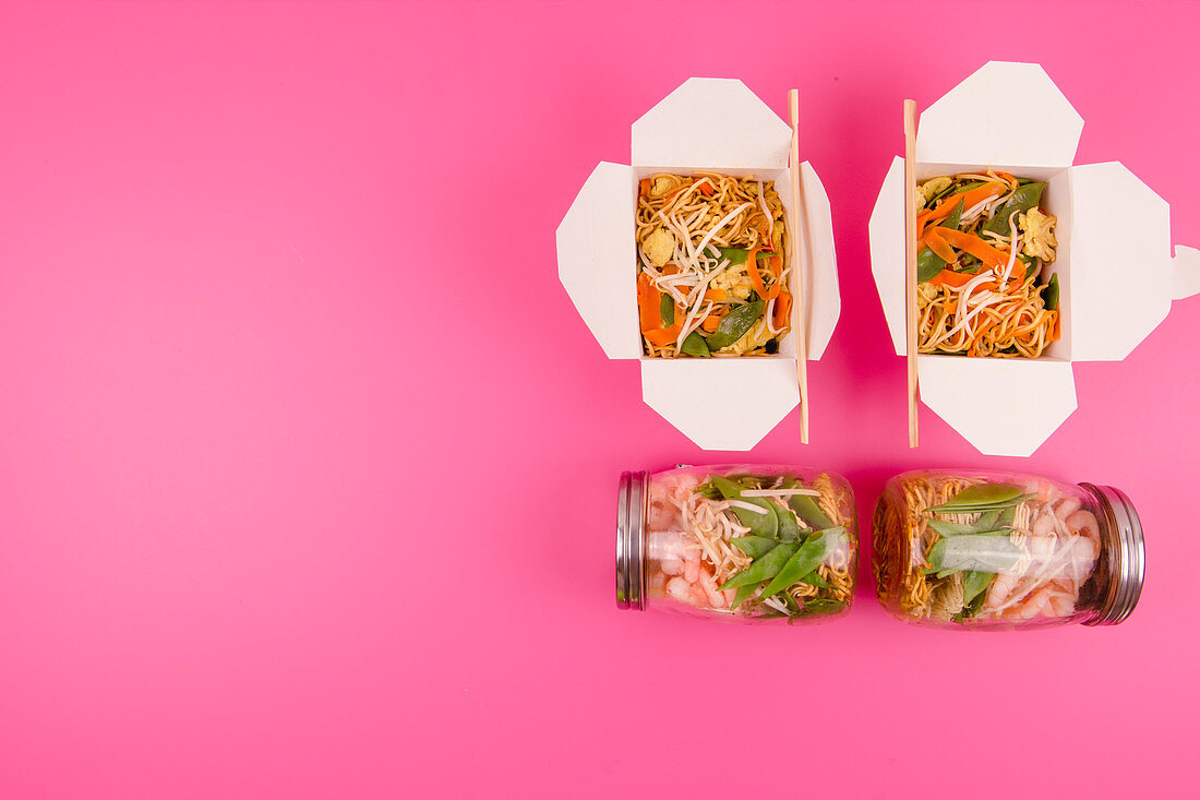Two different types of take-away oriental food – one with noodles and one with prawns