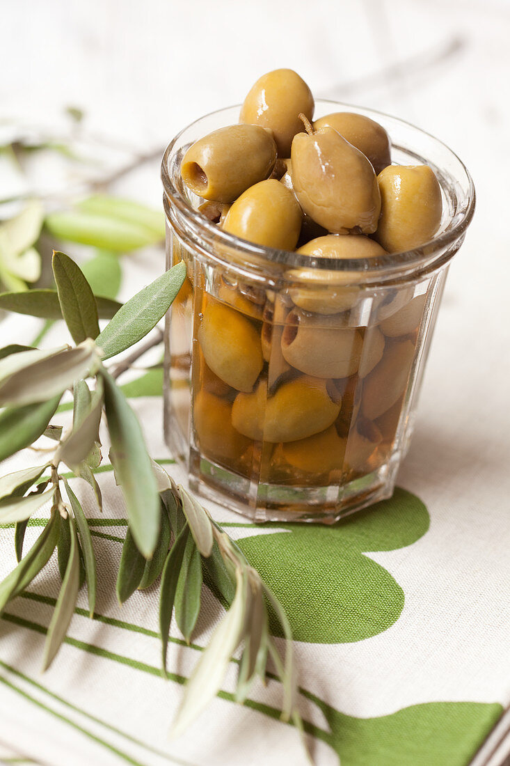 Pickled green olives in a glass