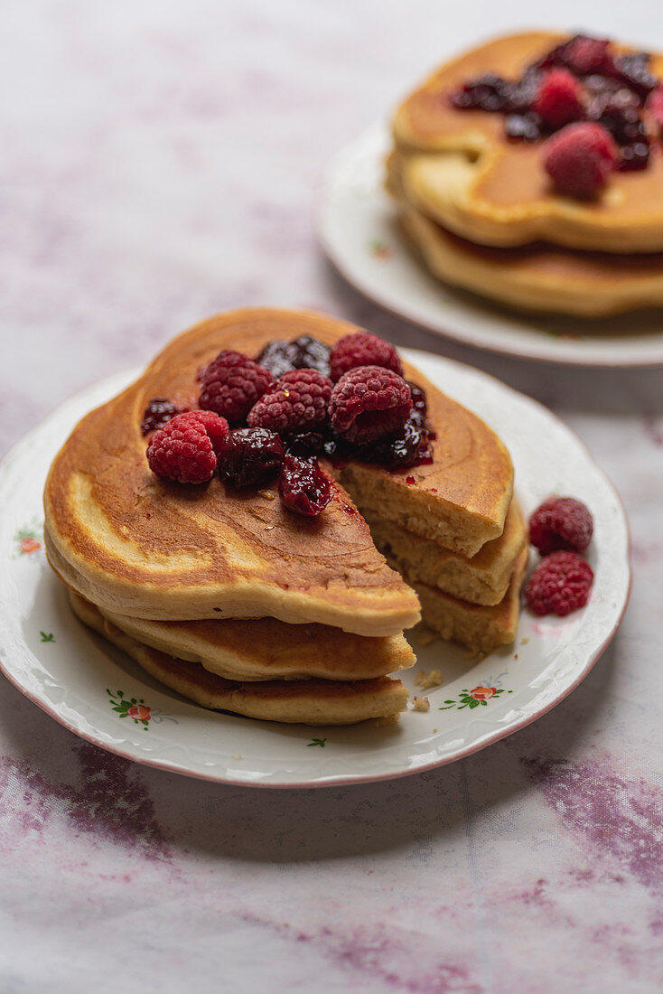 Stacked pancakes with berries and jam