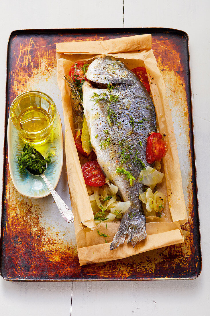 Herb dorade in paper with tomatoes and fennel