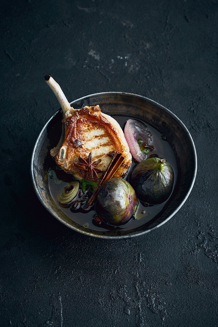 A grilled pork chop with star anise and figs
