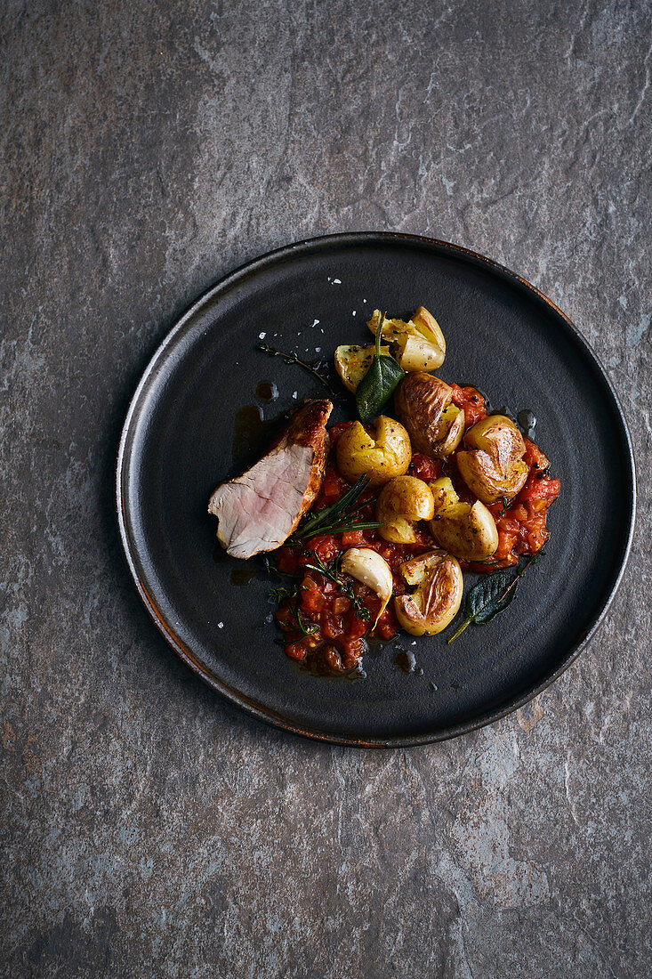 Gebratenes Schweinefilet mit kleinen Kartoffeln und Tomatensugo