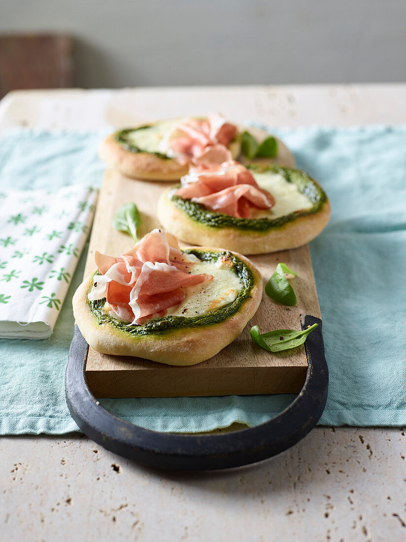 Minipizzen mit Spinat-Pistazien-Pesto, Käse und Rohschinken