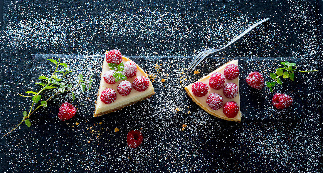 A slice of cheesecake with raspberries