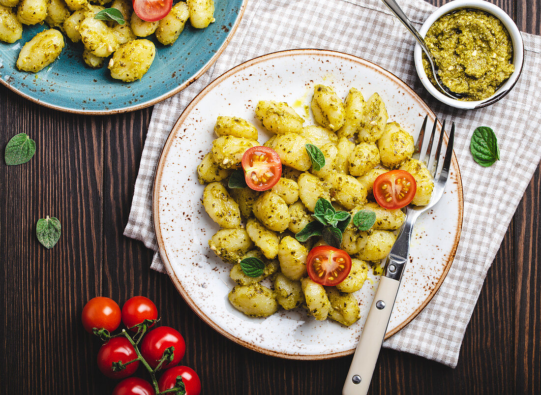 Gnocchi with green pesto sauce, tomatoes and herbs