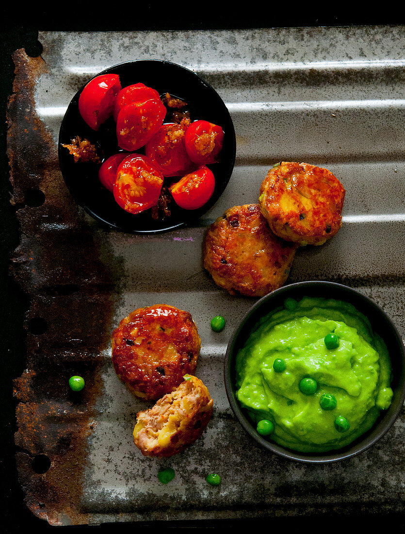 Sweetcorn fritters with mushy peas and roasted tomatoes